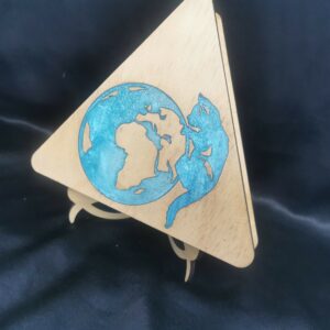 Support en bois triangulaire avec une gravure et découpe laser représentant un globe terrestre et un animal stylisé, coloré en bleu.